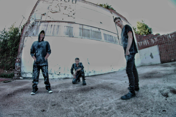 photo of three members from rock industrial band Shadowplay standing in front of a building